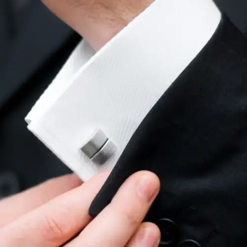 a man showing off a custom made cufflink in his shirt