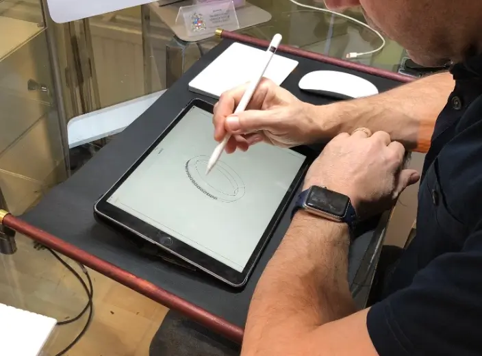 David Law, bespoke eternity ring designer, using an iPad to showcase custom designs, blending innovation with personal craftsmanship