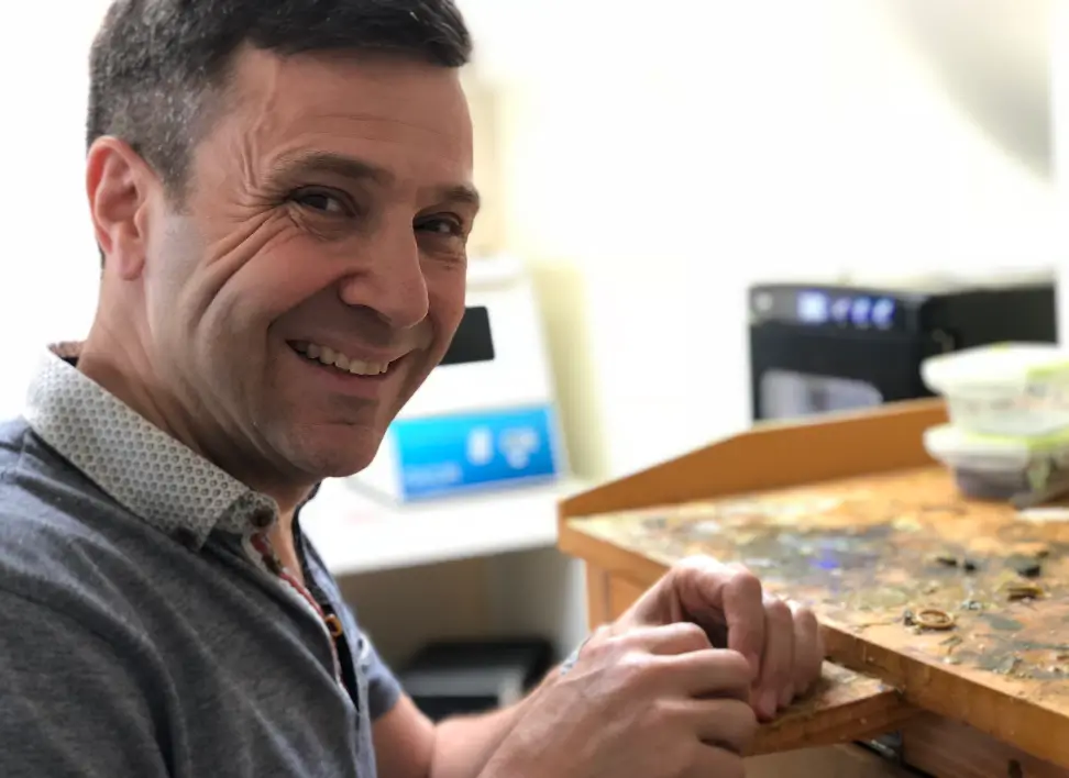 Jewellery designer David Law meticulously crafting a bespoke piece at his workbench.