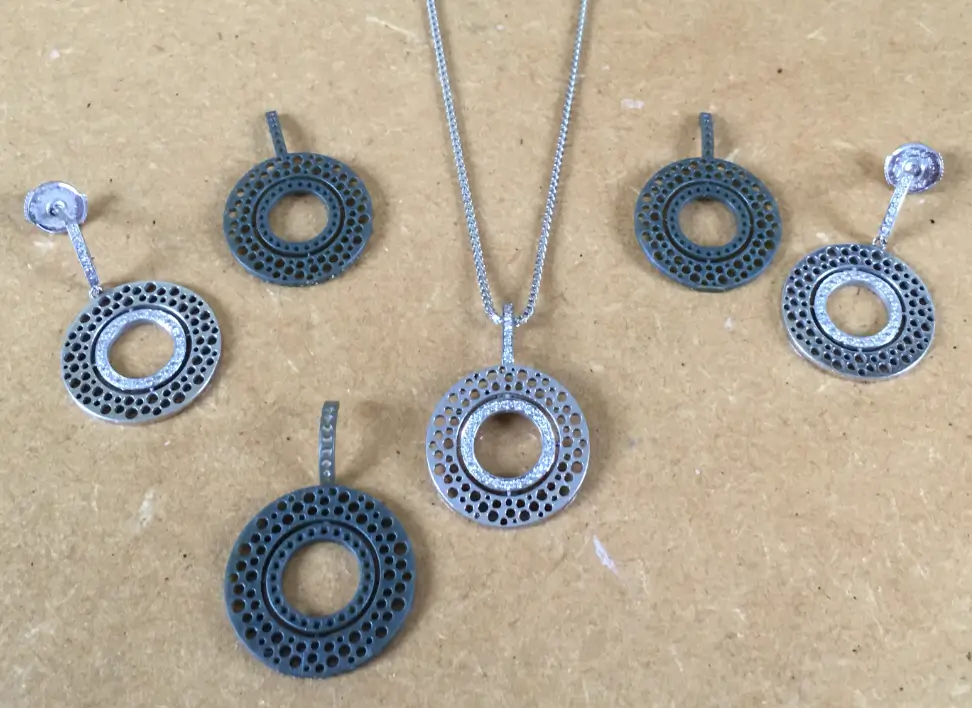 Diamond bespoke earrings and matching necklace set, showcased alongside wax models for a preview of the final handcrafted design.