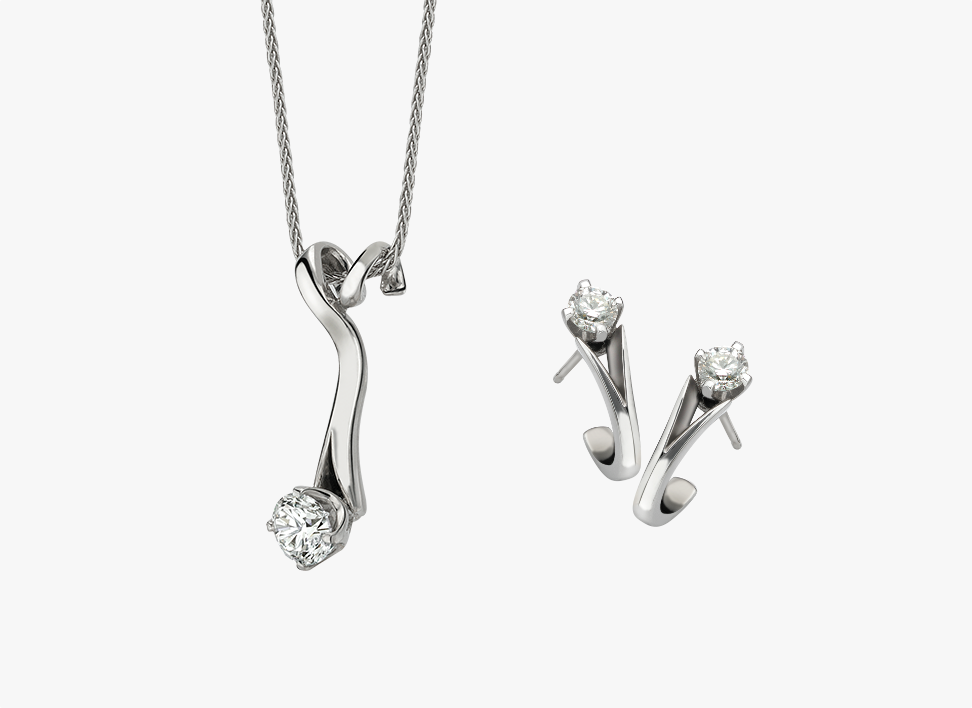 modern diamond drop pendant alongside matching diamond earrings