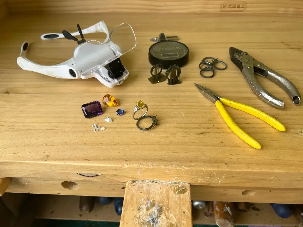 the bespoke experience settings and gemstones on the jewellers bench